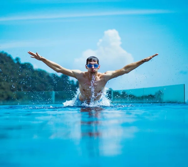Joven nadador musculoso salpicando agua Imagen de stock