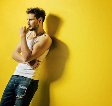 Yakışıklı adam parlak, sarı duvara yaslanmış