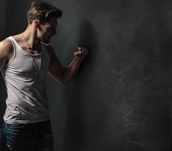 Furieux jeune homme frappant le mur de béton — Photo