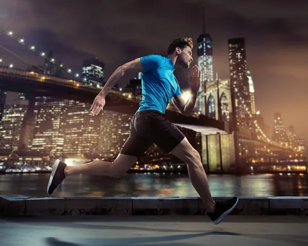 Bello jogger correre attraverso la città nella notte — Foto Stock
