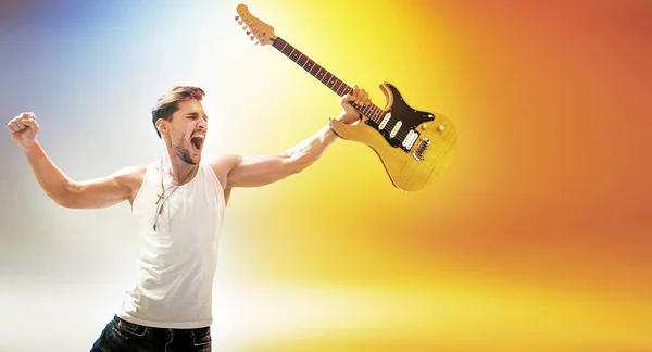 Retrato da jovem estrela de rock segurando uma guitarra — Fotografia de Stock