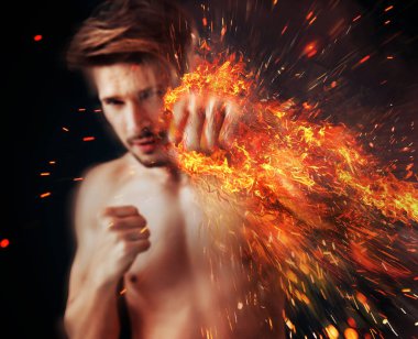Handsome athlete punching with flame around his fist clipart