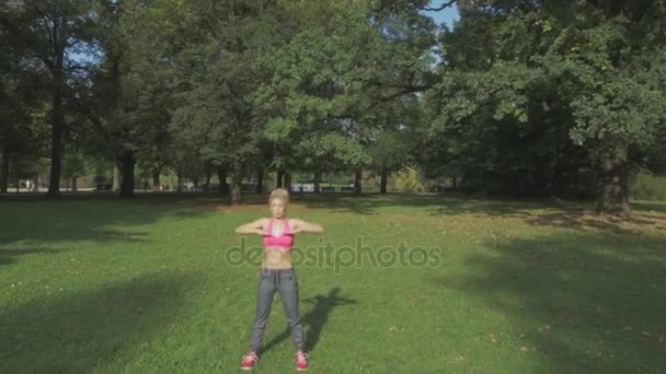 Подходит, молодая женщина растягивается в летнем парке — стоковое видео