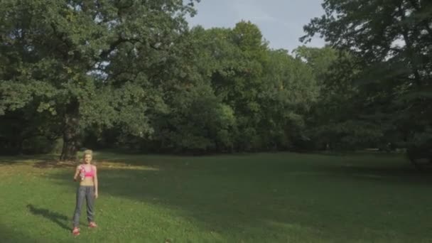 In forma, giovane donna che si allunga nel parco estivo — Video Stock