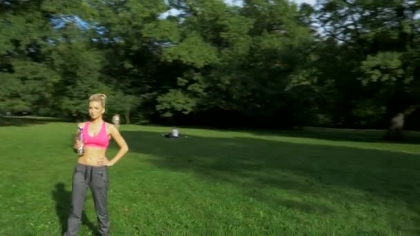 In forma, giovane donna che si allunga nel parco estivo — Video Stock