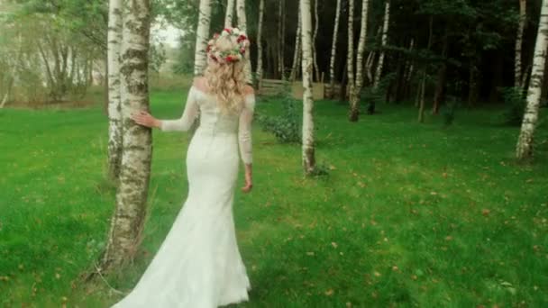 Finom szőke menyasszony séta a fák között — Stock videók