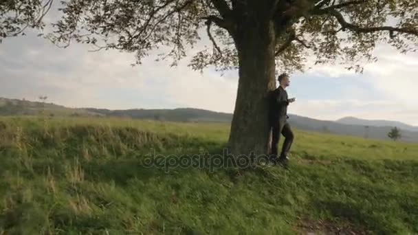 Hombre de negocios guapo cerca de la naturaleza — Vídeos de Stock