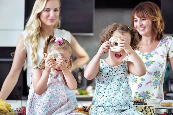 Güzel kadınlar çocuklarıyla birlikte tatlılar yemek