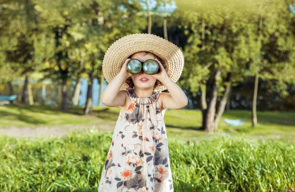 Portrait of a cheerful, little girl looking through the binocula — Stock Photo, Image