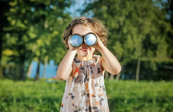 Retrato de uma menina alegre olhando através dos binóculos — Fotografia de Stock