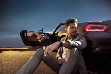 Yakışıklı adam lüks otomobili yaslanmış