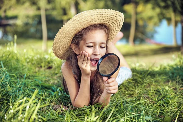 Söt flicka titta med förstoringsglas — Stockfoto