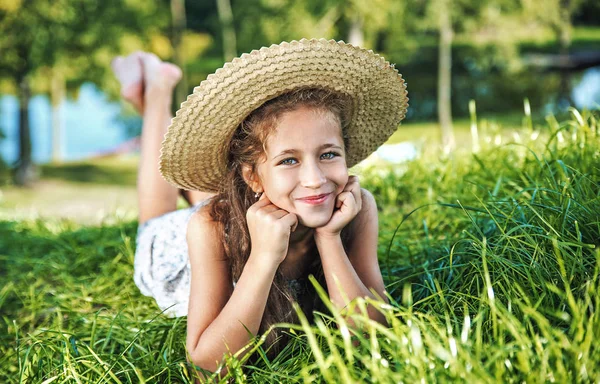 Jong meisje opleggen van verse, zomer gazon — Stockfoto