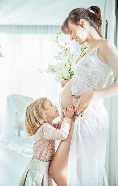 Veselá dcera objímat matčině břiše — Stock fotografie