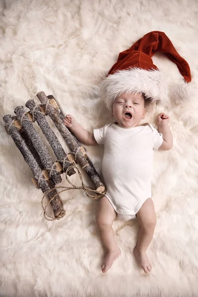 Yawning newborn child wearing a santa's hat — Stock Photo, Image