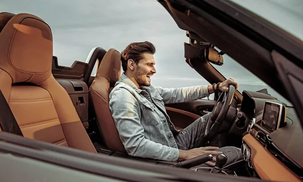 Schöner Mann fährt ein luxuriöses Cabrio — Stockfoto