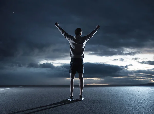 Junge Joggerin beobachtet den dunklen Himmel — Stockfoto