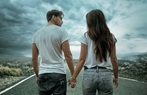 Two hitchhikers walking along the road — Stock Photo, Image