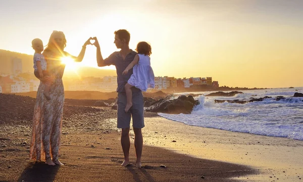 Padres jóvenes haciendo una señal del corazón — Foto de Stock