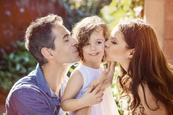 Gelukkige ouders hun geliefde kind kussen — Stockfoto