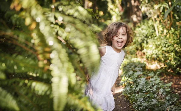 Pequena menina bonito se divertindo em um jardim tropical — Fotografia de Stock