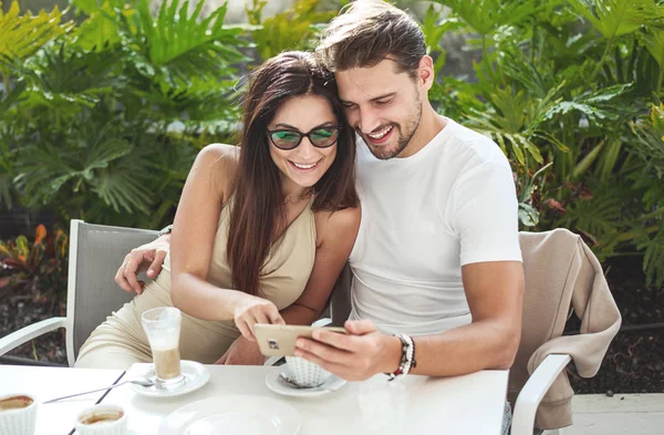 Atractiva pareja en el café, teléfono inteligente uisng — Foto de Stock