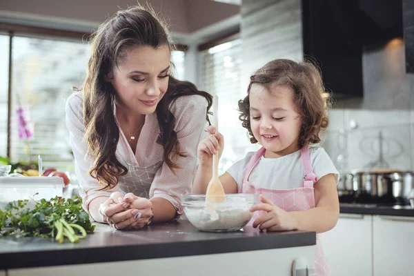 Μητέρα του βλέποντας την κόρη whisking ζύμη — Φωτογραφία Αρχείου