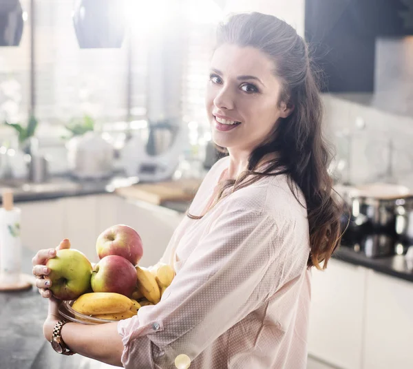 Fröhliche Frau mit einer Schale voller Früchte — Stockfoto