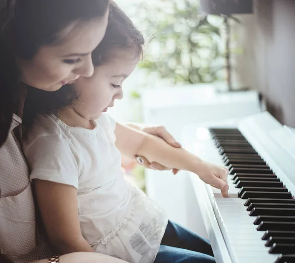 Moeder haar dochter piano leren spelen — Stockfoto