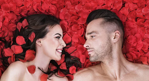 Романтична пара кладе на пелюстки троянд — стокове фото