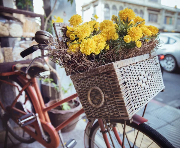 Imagen de cerca de una bicicleta vintage con flores en una cesta —  Fotos de Stock