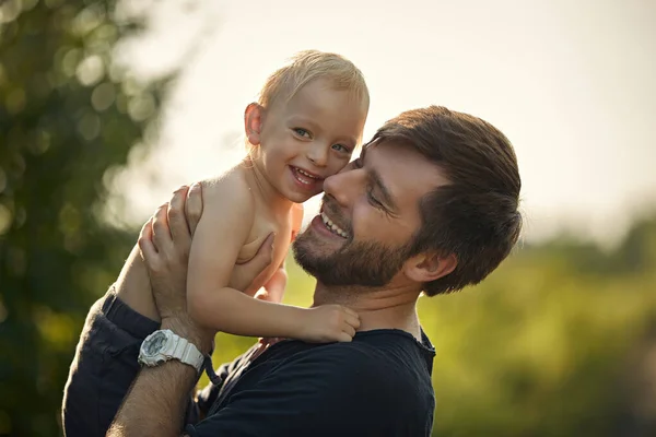 Sevgili oğlunu taşıyan neşeli bir babanın yakın plan portresi. — Stok fotoğraf