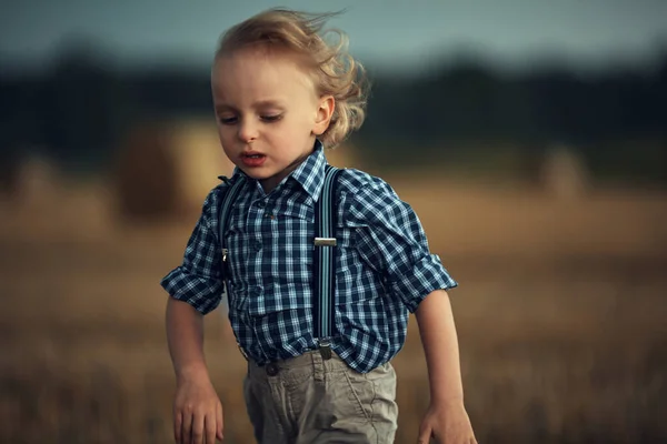 Retrato de perto de um menino loiro correndo no trigo fiel — Fotografia de Stock