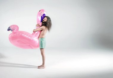 Lastik flamingo tutan sıska adam, izole edilmiş.