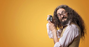 Küçük bir kamerayla fotoğraf çeken tuhaf bir inek.
