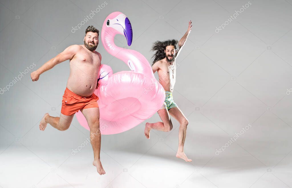 Two funny friends holding pool float bird