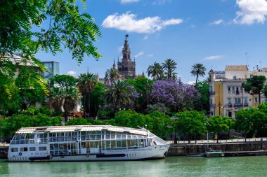 Sevilla, Endülüs, İspanya - 14 Mayıs 2013: Arka planda Giralda ile Guadalquivir 'de gezinti yapan gemi.