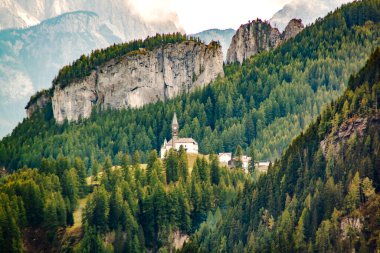 İtalya 'nın Dolomite Alpleri' nde bir dağ ormanının arka planında küçük bir kilise.. 