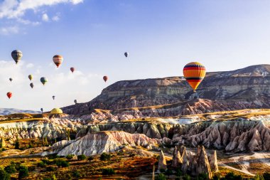 Goreme / Nevsehir, Türkiye - 27 Eylül 2019: Türkiye 'nin Kapadokya kentindeki vadi üzerinde uçan renkli sıcak hava balonları. Goreme Ulusal Parkı 'ndaki volkanik dağlar.