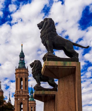 Zaragoza, İspanya - 10 Ekim 2012: Piedra köprüsündeki aslan heykelleri mavi bulutlu gökyüzüne karşı