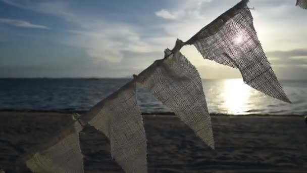 Vintage flage decorate at beach with sunset sky at sea background (Handheld) — Stock Video