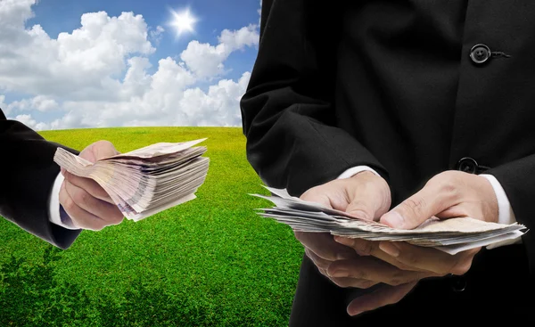 Businessmen carry money with nice landscape background — Stock Photo, Image