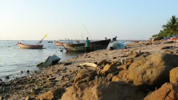 Lapso de tempo do pescador limpando a rede com barco à beira-mar — Vídeo de Stock