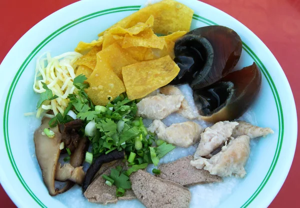 Gachas de arroz con huevo conservado y wonton crujiente —  Fotos de Stock