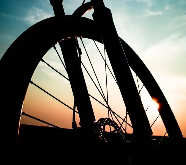 Mountain bike wheel close up shot with sunset sky background — Stock Photo, Image