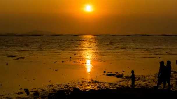 Time-lapse van zonsondergang op zee met silhouet van mensen — Stockvideo