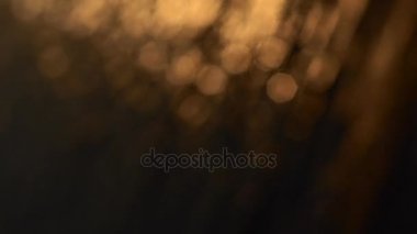 Soyut parlak ışık bokeh hareketi, su yüzeyinde günbatımı ışık yansıması