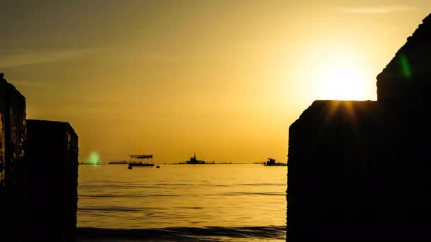 4K Time lapse of sunset sky at sea with concrete block silhouette foreground — Stock Video