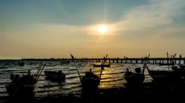 4 k zaman atlamalı iskele Köprüsü siluet ön ve balıkçı teknesi ile deniz günbatımı gökyüzünün