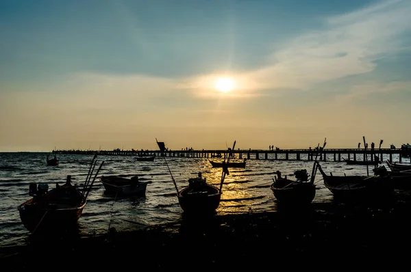 Pôr do sol no mar com silhueta de barco e molhe primeiro plano — Fotografia de Stock